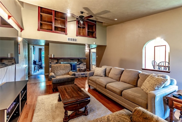 2606 Cedar Elm Ln, Garland, TX 75043 - living room with a fireplace, ceiling fan, wood finished floors, and a high ceiling