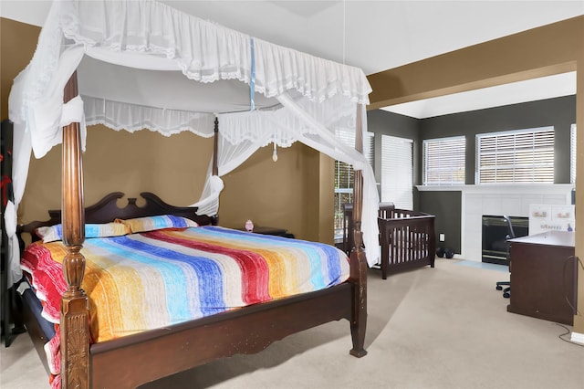 carpeted bedroom featuring a tiled fireplace