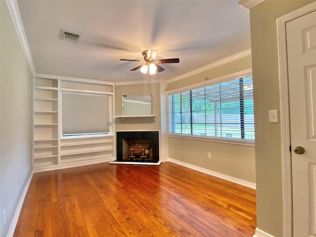 unfurnished living room featuring a fireplace, ceiling fan, baseboards, ornamental molding, and wood finished floors