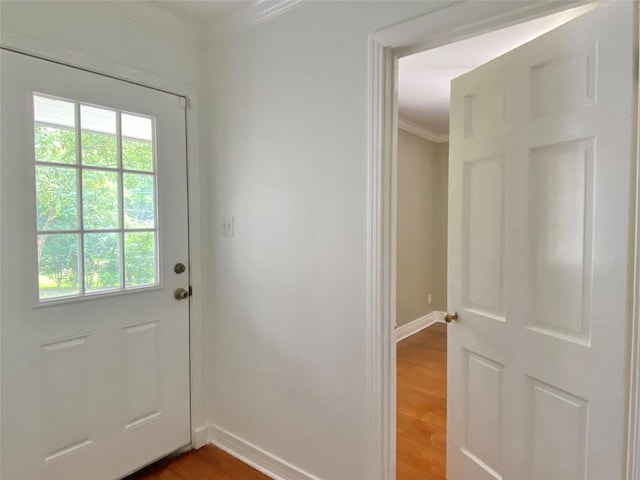 doorway to outside with ornamental molding, baseboards, and wood finished floors
