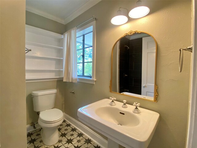bathroom featuring tile patterned floors, baseboards, toilet, ornamental molding, and a sink