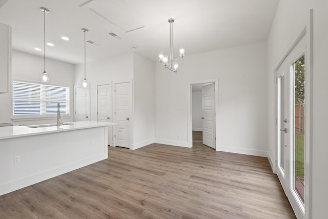 607 W Sears St, Denison, TX 75020 - unfurnished living room featuring light wood-style flooring, baseboards, recessed lighting, a sink, and a chandelier