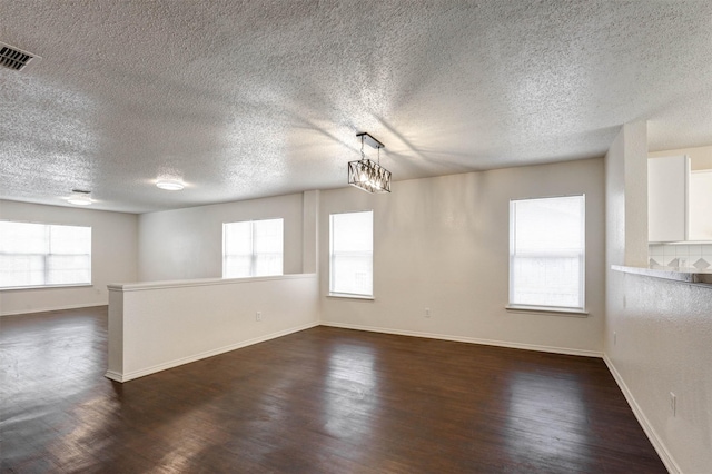 914 Gillon Dr, Arlington, TX 76001 - unfurnished room featuring dark wood finished floors, a textured ceiling, and baseboards