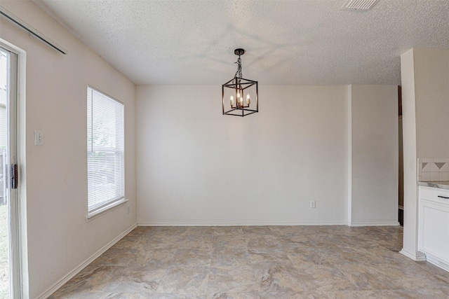 914 Gillon Dr, Arlington, TX 76001 - unfurnished dining area with a textured ceiling and a chandelier