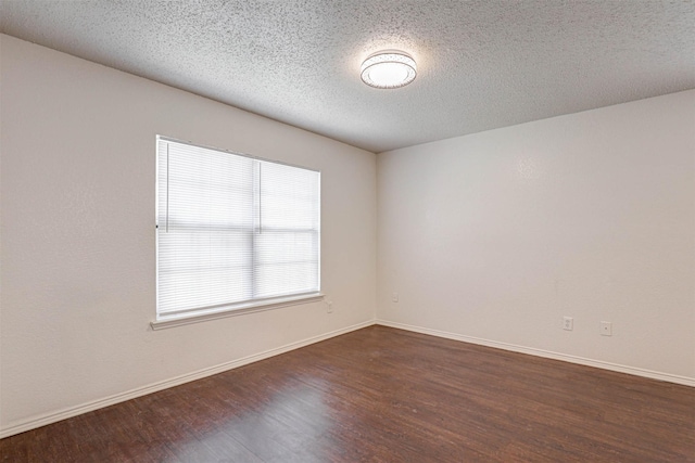 914 Gillon Dr, Arlington, TX 76001 - empty room with dark wood-type flooring, baseboards, and a textured ceiling