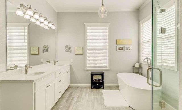 1926 N Stodghill Rd, Rockwall, TX 75087 - bathroom featuring a freestanding bath, double vanity, baseboards, crown molding, and wood finished floors