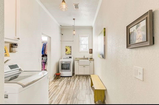 1926 N Stodghill Rd, Rockwall, TX 75087 - clothes washing area featuring cabinet space, crown molding, light wood-style flooring, and separate washer and dryer