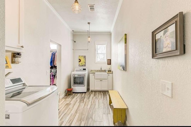 1926 N Stodghill Rd, Rockwall, TX 75087 - laundry area with crown molding, cabinet space, separate washer and dryer, and light wood-style floors