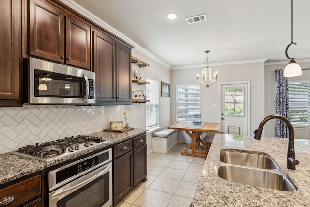 7745 Northumberland Dr, Fort Worth, TX 76179 - kitchen featuring appliances with stainless steel finishes, a sink, tasteful backsplash, dark brown cabinetry, and decorative light fixtures