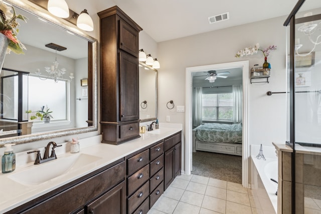 7745 Northumberland Dr, Fort Worth, TX 76179 - ensuite bathroom featuring tile patterned floors, double vanity, a bath, ceiling fan, and a chandelier