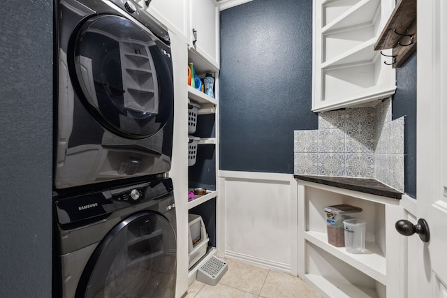 7745 Northumberland Dr, Fort Worth, TX 76179 - washroom with stacked washer / dryer, cabinet space, and light tile patterned flooring