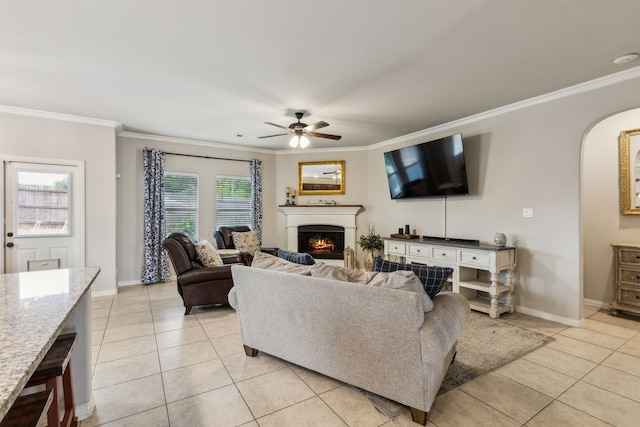 7745 Northumberland Dr, Fort Worth, TX 76179 - living area featuring ceiling fan, light tile patterned floors, crown molding, a lit fireplace, and baseboards