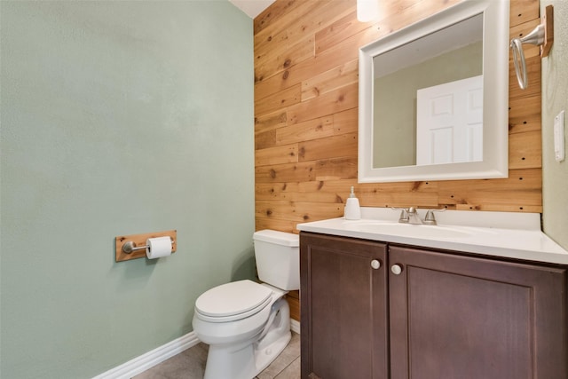 8404 Forest Ln Unit 1305, Dallas, TX 75243 - bathroom featuring wood walls, toilet, baseboards, vanity, and tile patterned flooring