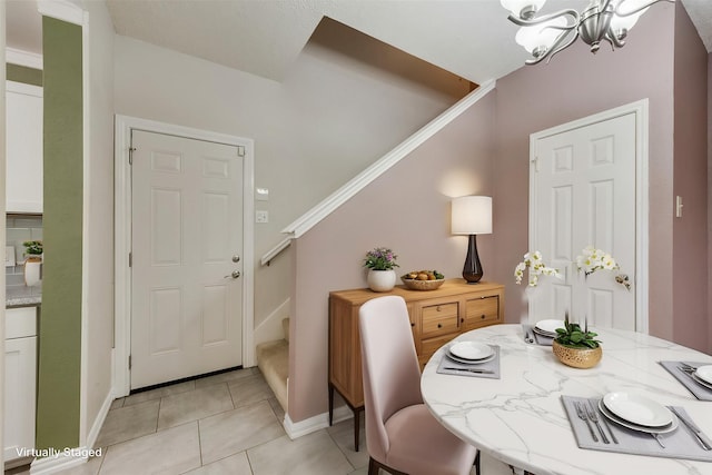 8404 Forest Ln Unit 1305, Dallas, TX 75243 - foyer featuring stairs, a chandelier, light tile patterned flooring, and baseboards