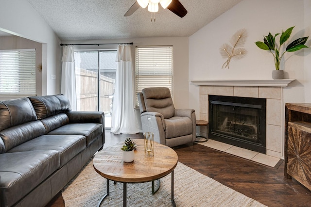 6713 Windwillow Dr, Fort Worth, TX 76137 - living area featuring a ceiling fan, a textured ceiling, wood finished floors, a tile fireplace, and lofted ceiling
