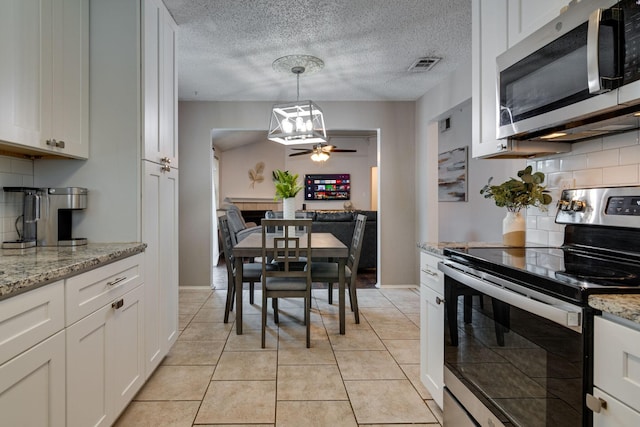 6713 Windwillow Dr, Fort Worth, TX 76137 - kitchen featuring stainless steel appliances, decorative backsplash, white cabinets, ceiling fan, and a textured ceiling