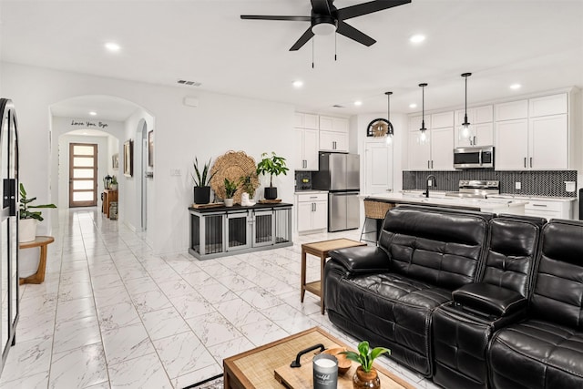 1096 Tupuna Ct, Tool, TX 75143 - living room featuring a ceiling fan, arched walkways, light marble finish flooring, and recessed lighting
