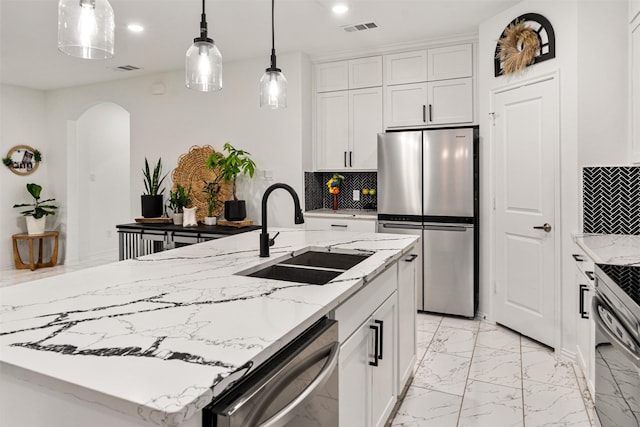 1096 Tupuna Ct, Tool, TX 75143 - kitchen with appliances with stainless steel finishes, a sink, light marble finish flooring, arched walkways, and decorative backsplash