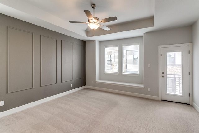 8230 Callimont Ln, Dallas, TX 75231 - empty room with light colored carpet, baseboards, a raised ceiling, and a ceiling fan