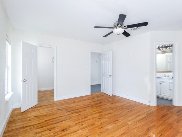 1803 4th St, Brownwood, TX 76801 - unfurnished bedroom with light wood finished floors, baseboards, and a walk in closet