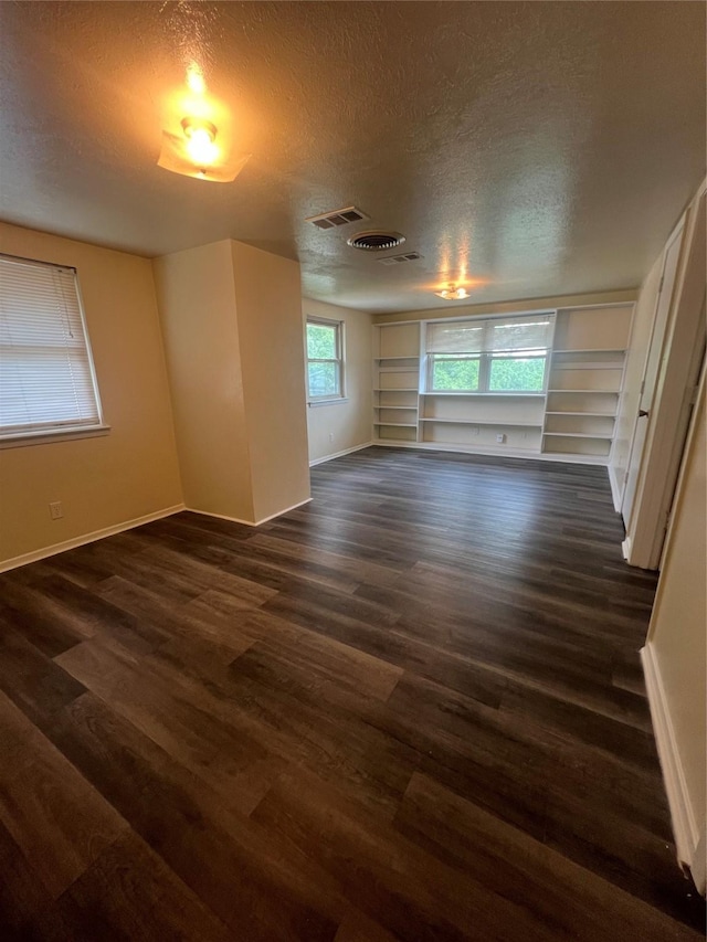 5708 Melinda St, Haltom City, TX 76117 - spare room featuring a textured ceiling, baseboards, and dark wood-style flooring