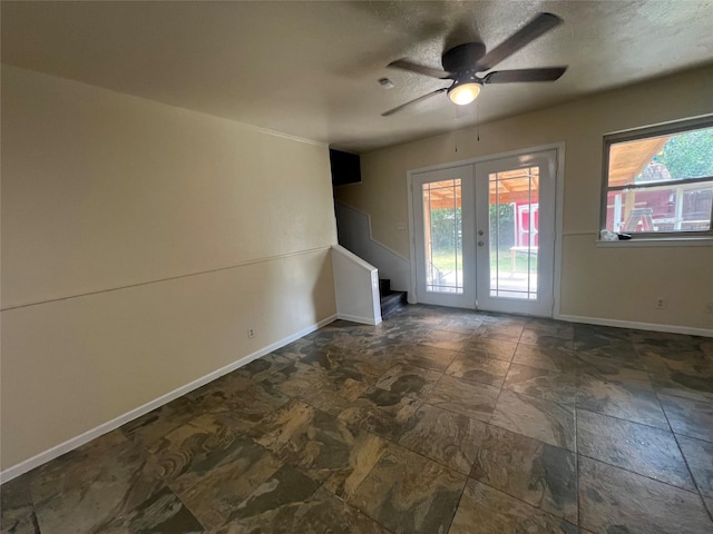 5708 Melinda St, Haltom City, TX 76117 - unfurnished room featuring french doors, stone finish flooring, a ceiling fan, baseboards, and a textured ceiling