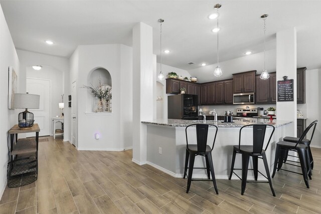 725 Sandy Chip Trl, Fort Worth, TX 76108 - kitchen featuring stainless steel microwave, freestanding refrigerator, dark brown cabinetry, a kitchen breakfast bar, and recessed lighting