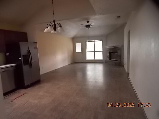 6107 Brookfall Dr, Arlington, TX 76018 - unfurnished living room with a ceiling fan, a chandelier, vaulted ceiling, and a glass covered fireplace