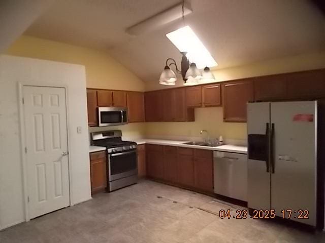 6107 Brookfall Dr, Arlington, TX 76018 - kitchen with stainless steel appliances, a sink, vaulted ceiling, light countertops, and brown cabinets
