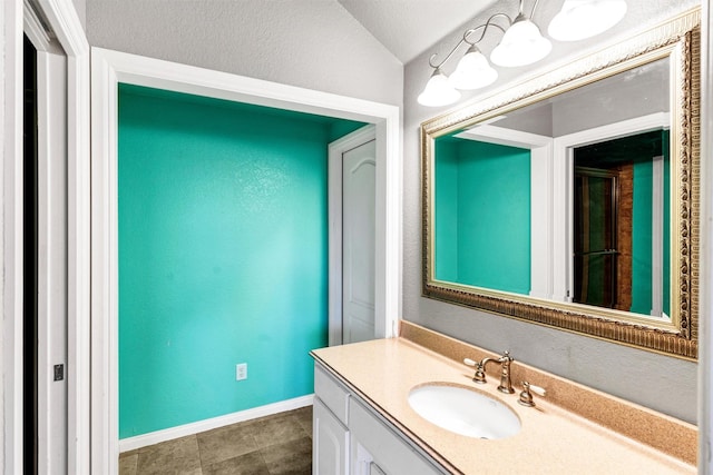620 Timber Creek Cir, Stephenville, TX 76401 - bathroom with a textured wall, vanity, baseboards, and vaulted ceiling