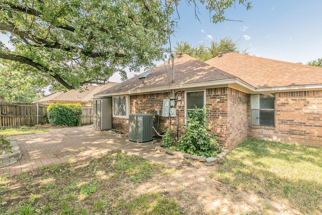 4107 Crossgate Ct, Arlington, TX 76016 - rear view of house featuring central air condition unit, brick siding, roof with shingles, and a patio
