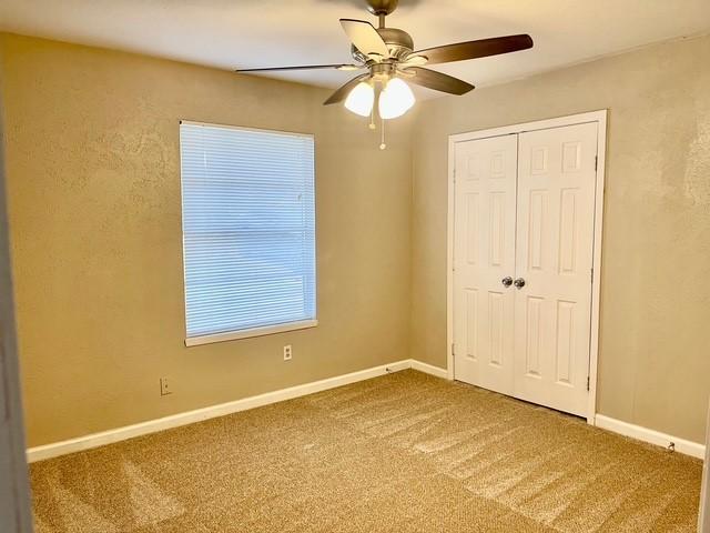 5636 Cherilee Ln, Haltom City, TX 76148 - unfurnished bedroom featuring carpet, a closet, baseboards, and ceiling fan
