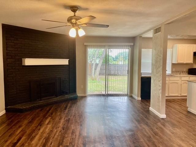 5636 Cherilee Ln, Haltom City, TX 76148 - unfurnished living room featuring a ceiling fan, dark wood finished floors, baseboards, and a brick fireplace