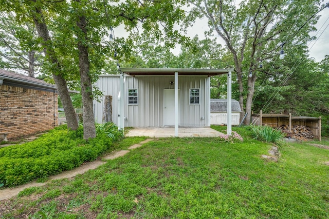 146 Circle Dr, Denison, TX 75021 - back of house with board and batten siding, a lawn, and an outdoor structure
