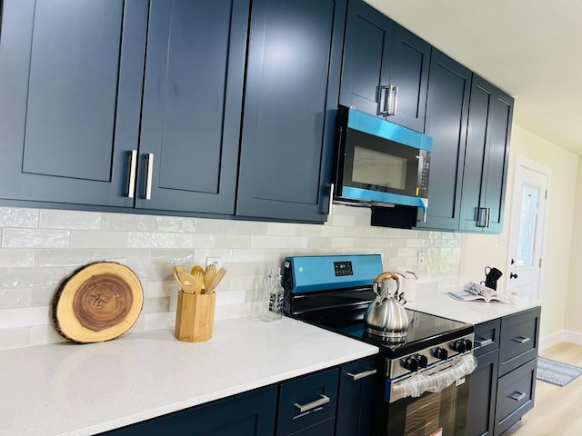 1218 Ralph St, Grand Prairie, TX 75051 - kitchen featuring stainless steel appliances, light countertops, decorative backsplash, and blue cabinetry