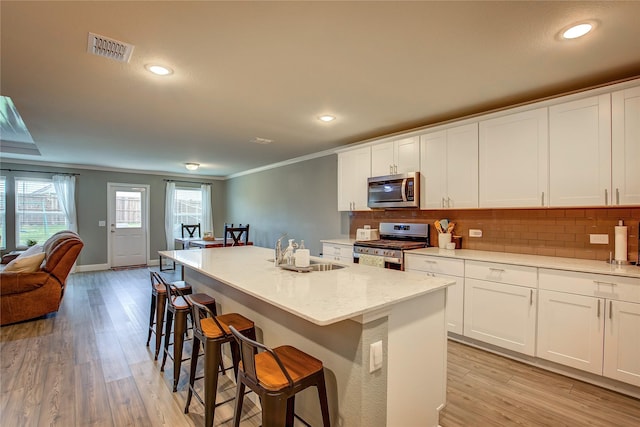 1908 Damianita Dr, Royse City, TX 75189 - kitchen featuring appliances with stainless steel finishes, a sink, ornamental molding, tasteful backsplash, and light wood-style flooring
