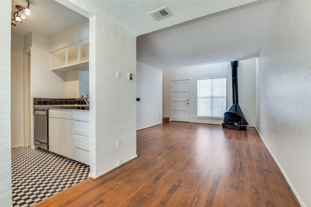 4211 Holland Ave Unit 206, Dallas, TX 75219 - kitchen with dishwasher, open shelves, wood finished floors, baseboards, and a textured ceiling
