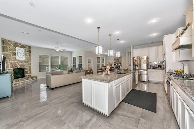 8109 Brahmin Ct, Fort Worth, TX 76131 - kitchen with a sink, stainless steel appliances, open floor plan, light stone countertops, and recessed lighting