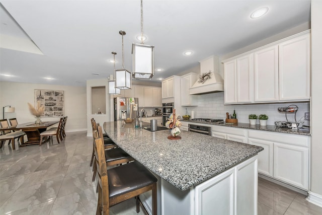 8109 Brahmin Ct, Fort Worth, TX 76131 - kitchen featuring appliances with stainless steel finishes, a sink, custom range hood, dark stone counters, and white cabinetry
