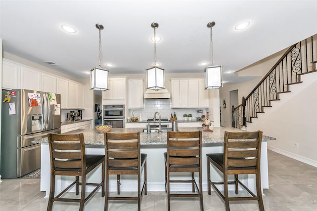 8109 Brahmin Ct, Fort Worth, TX 76131 - kitchen with appliances with stainless steel finishes, premium range hood, white cabinets, backsplash, and a breakfast bar