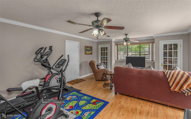 living room with wood finished floors, ceiling fan, crown molding, and a textured ceiling