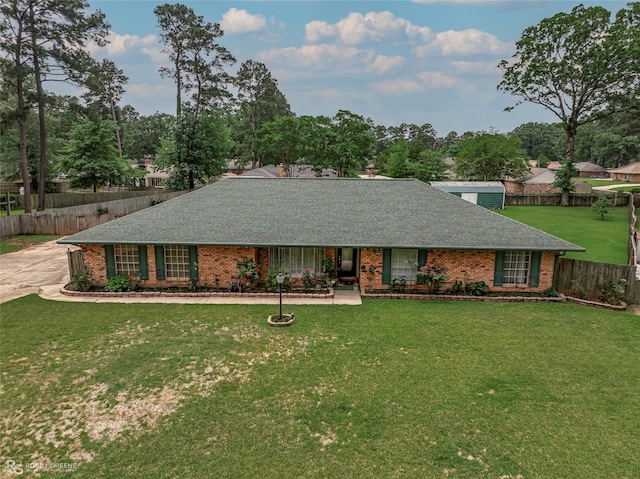ranch-style house with roof with shingles, brick siding, and view of scattered trees
