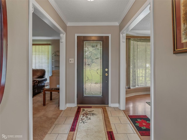 entrance foyer featuring light tile patterned floors, baseboards, a textured ceiling, crown molding, and light carpet
