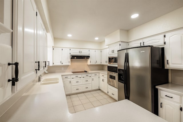 kitchen featuring stainless steel appliances, under cabinet range hood, white cabinetry, a sink, and light countertops