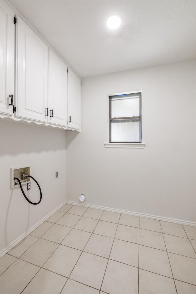 laundry area featuring cabinet space, washer hookup, baseboards, electric dryer hookup, and light tile patterned floors