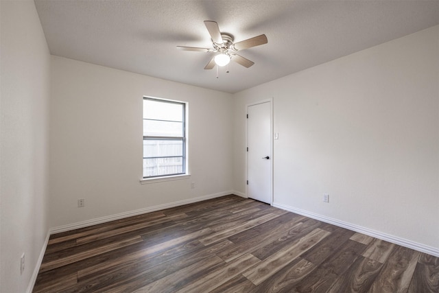 spare room with a ceiling fan, dark wood-style floors, baseboards, and a textured ceiling