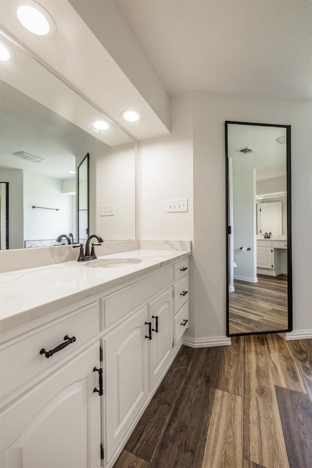 bathroom with wood finished floors, vanity, and baseboards