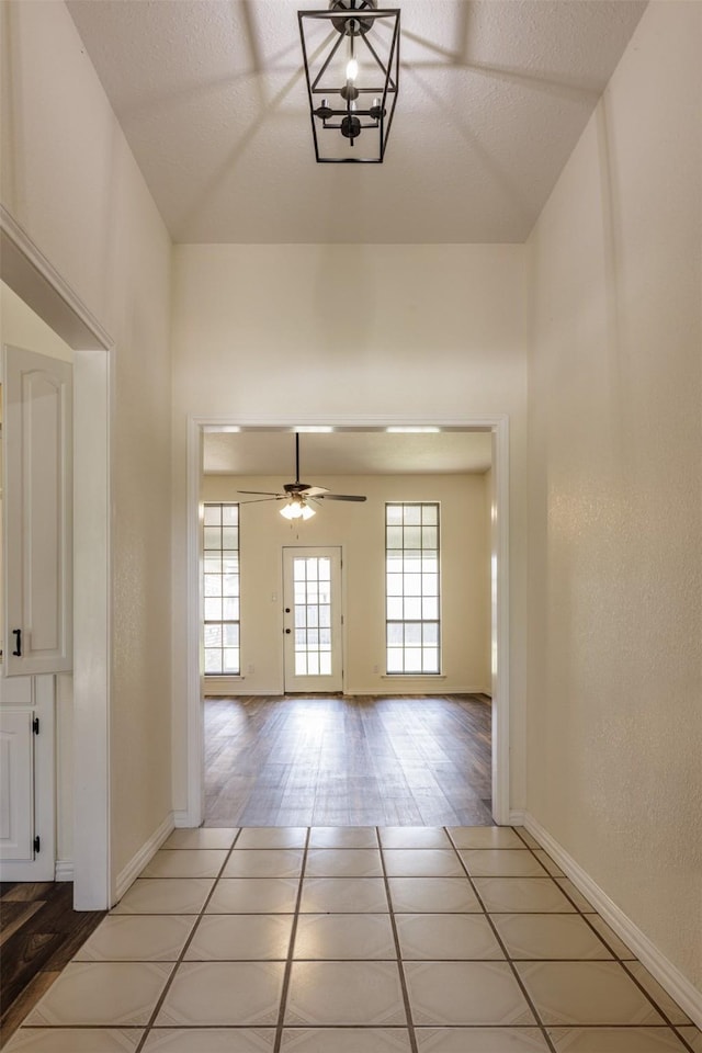 hall with baseboards and light tile patterned floors