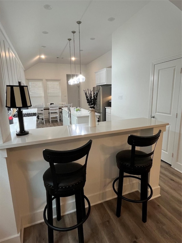 1812 Horseshoe Ln, Van Alstyne, TX 75495 - kitchen with freestanding refrigerator, white cabinets, dark wood-style floors, a kitchen bar, and decorative light fixtures