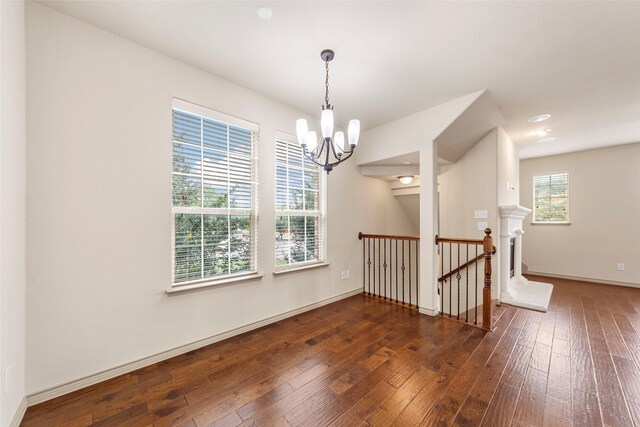 7941 Parkwood Blvd, Plano, TX 75024 - spare room featuring a chandelier, wood-type flooring, and baseboards
